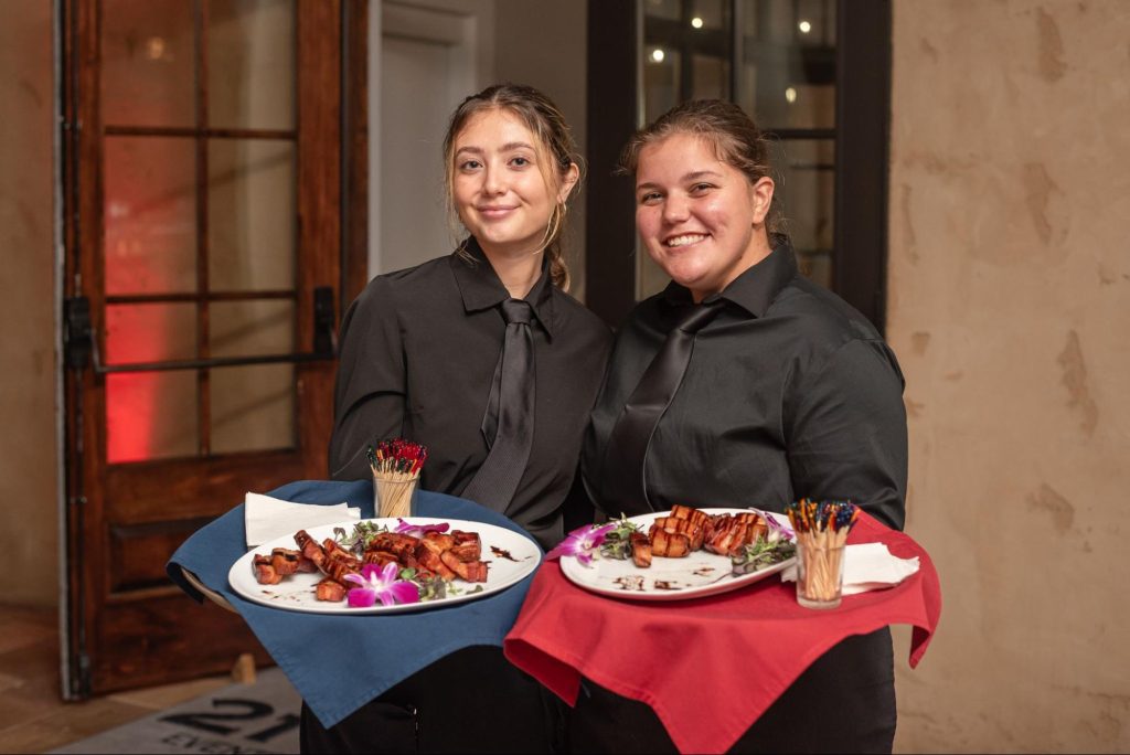 image of 2 person showcasing the food in the event
