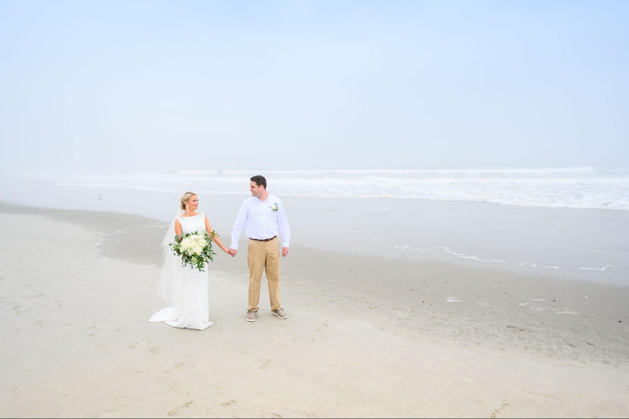 image of couple walking by the beach