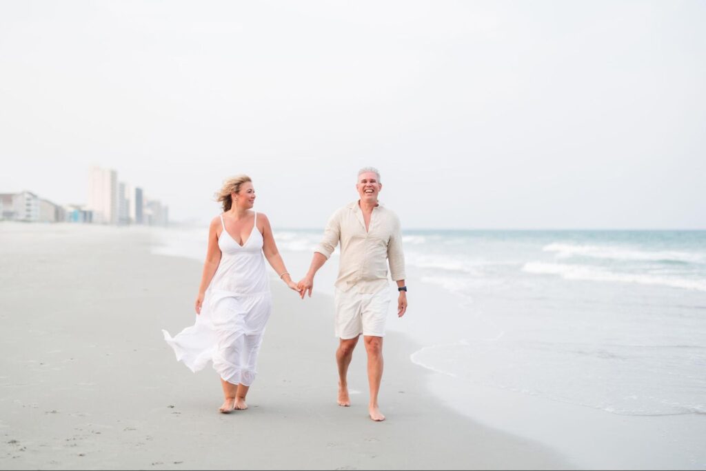 image of couple walking by the beach
