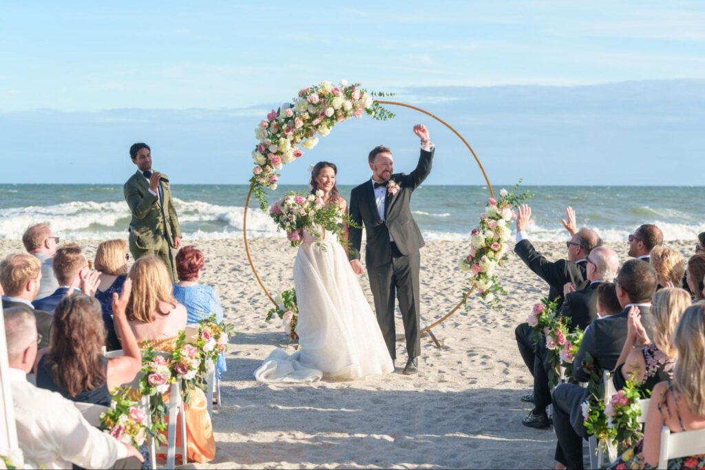 Beach wedding ceremony setup at 21 Main Events in Myrtle Beach with white garden chairs and gold circular arbor overlooking the ocean